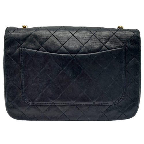 82 - Black Chanel Handbag.
Quilted leather stitched in diamond pattern. Gold & Silver toned hardware with... 