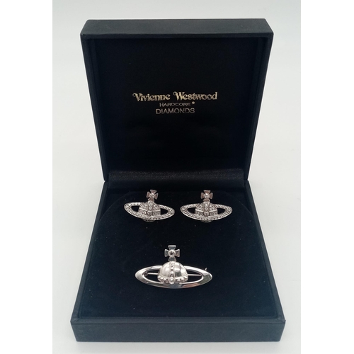 262 - An 18 K white gold VIVIENNE WESTWOOD HARDCORE DIAMOND pair of cufflinks and brooch set with the icon... 