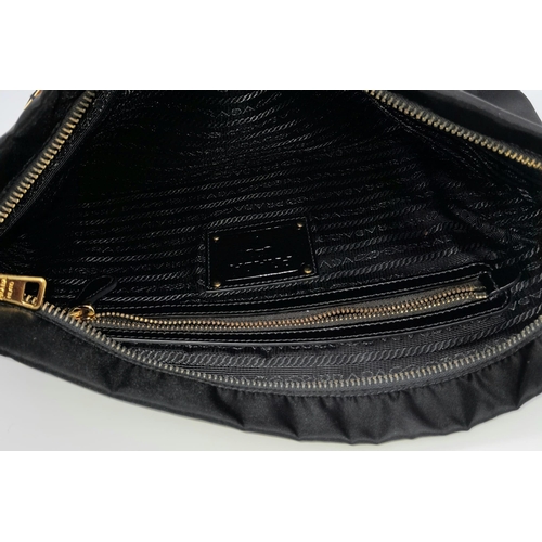 293 - A Prada Black Jewel Clutch. Textile exterior embellished with black stones. Gold toned hardware and ... 