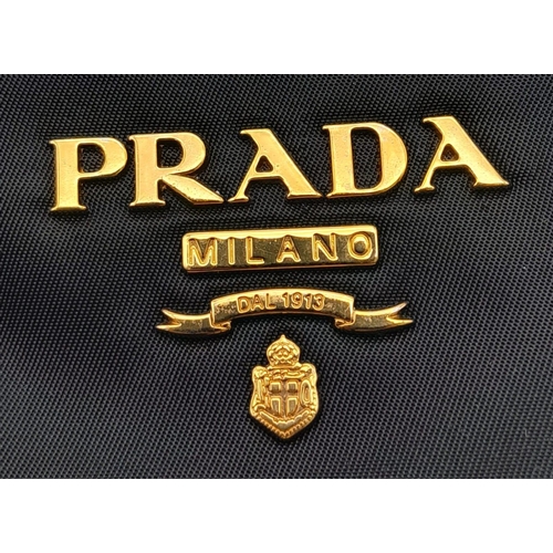 293 - A Prada Black Jewel Clutch. Textile exterior embellished with black stones. Gold toned hardware and ... 