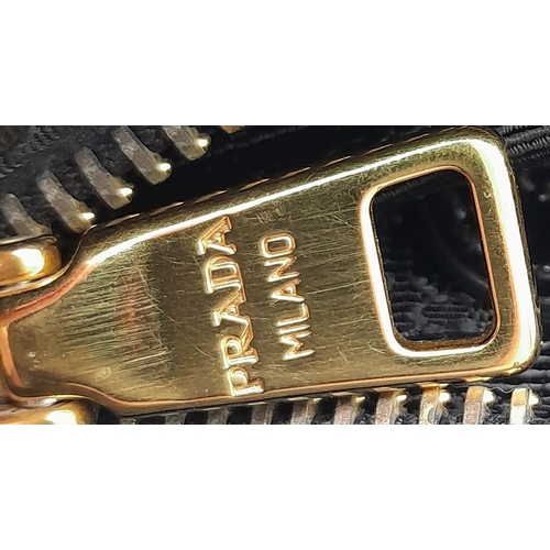 293 - A Prada Black Jewel Clutch. Textile exterior embellished with black stones. Gold toned hardware and ... 