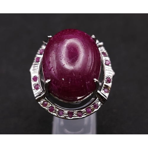 318 - A Ruby Gemstone and 925 Silver Ring. Oval cut central cabochon with ruby halo. Size O. 19g total wei... 