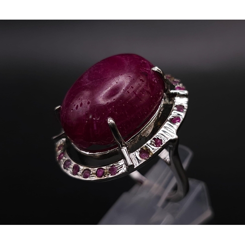 318 - A Ruby Gemstone and 925 Silver Ring. Oval cut central cabochon with ruby halo. Size O. 19g total wei... 