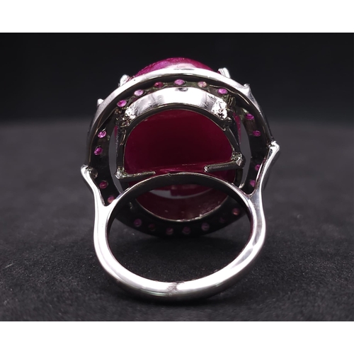 318 - A Ruby Gemstone and 925 Silver Ring. Oval cut central cabochon with ruby halo. Size O. 19g total wei... 