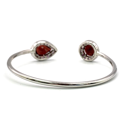 1766 - A Garnet and Ruby Cuff Bangle. Set in 925 Sterling silver. Garnet - 4.80ctw. 13.603g total weight. C... 