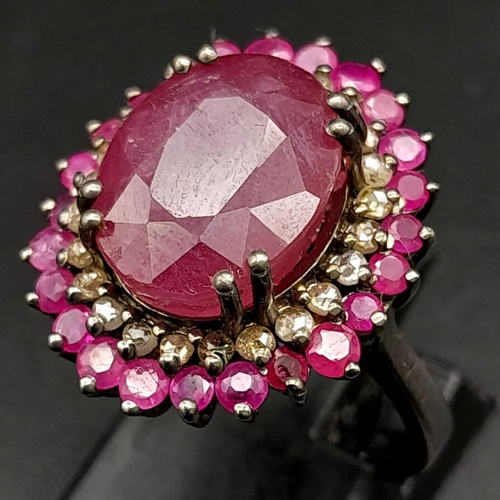 1767 - An 11.40ct Ruby Gemstone Ring with a 0.50ct Diamond Halo. Set in 925 Silver. Size M/N. Comes with a ... 