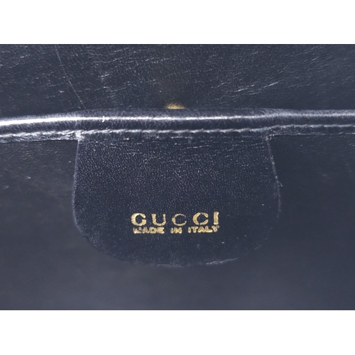 213 - Black Gucci Top Handle Bag.
Exotic, shiny lizard leather featuring gold toned hardware, flip-lock cl... 