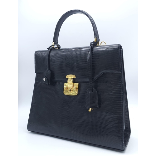 213 - Black Gucci Top Handle Bag.
Exotic, shiny lizard leather featuring gold toned hardware, flip-lock cl... 