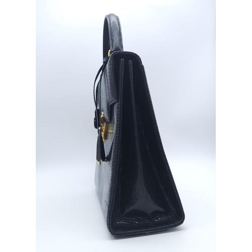 213 - Black Gucci Top Handle Bag.
Exotic, shiny lizard leather featuring gold toned hardware, flip-lock cl... 