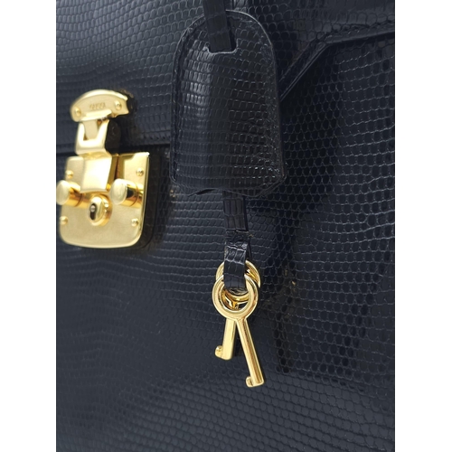 213 - Black Gucci Top Handle Bag.
Exotic, shiny lizard leather featuring gold toned hardware, flip-lock cl... 