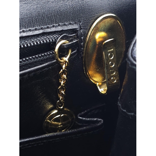 213 - Black Gucci Top Handle Bag.
Exotic, shiny lizard leather featuring gold toned hardware, flip-lock cl... 