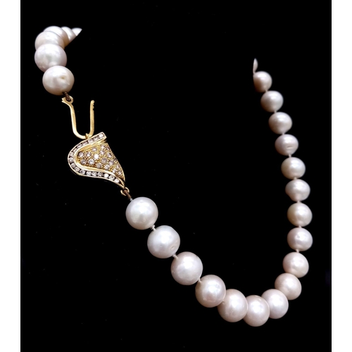 269 - A very glamorous vintage pearl necklace with a beautiful yellow gold asymmetric clasp loaded with ro... 