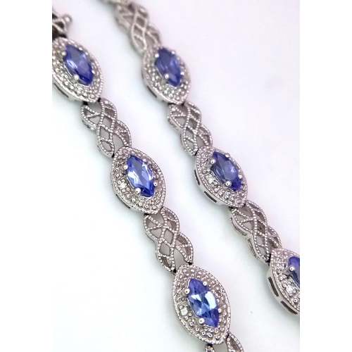 31 - A 9K White Gold, Purple Sapphire and Diamond Tennis Bracelet. Eye-shaped links with sapphire centres... 