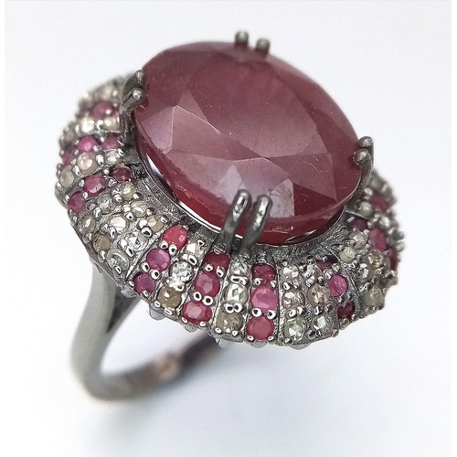 1773 - An 11.75ct Oval Ruby Ring with 0.80ctw of Ruby and 1.3ctw of diamond accents. Set in 925 silver. Siz... 