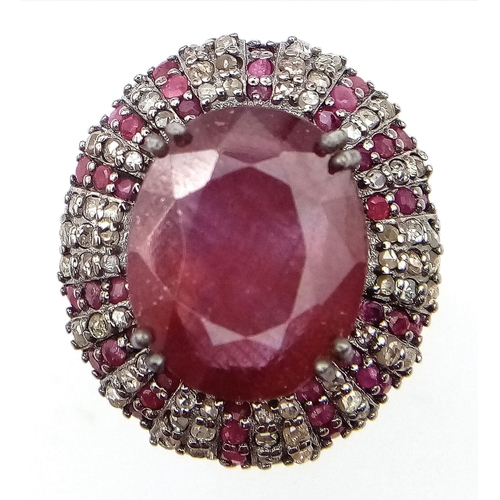 1773 - An 11.75ct Oval Ruby Ring with 0.80ctw of Ruby and 1.3ctw of diamond accents. Set in 925 silver. Siz... 