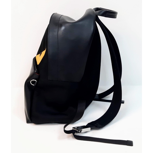 138 - A Fendi Monster Black Backpack. Canvas and leather exterior, with two large yellow monster eyes, a z... 