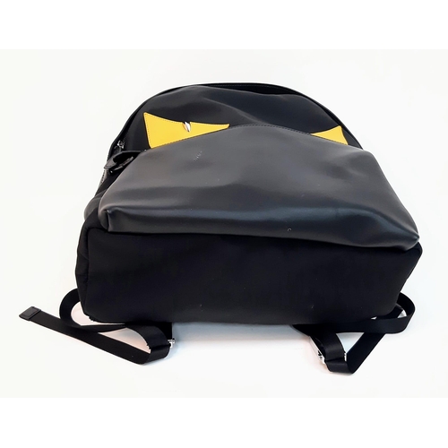 138 - A Fendi Monster Black Backpack. Canvas and leather exterior, with two large yellow monster eyes, a z... 