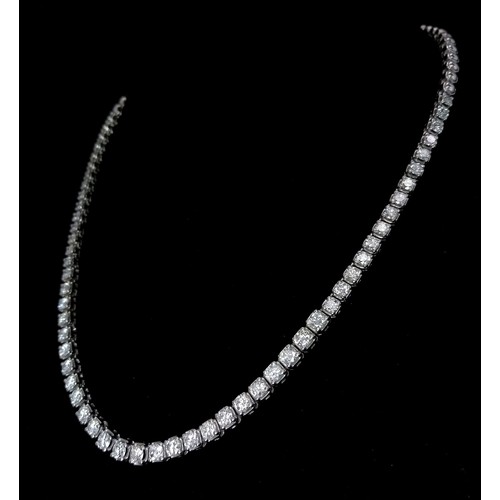 122 - An 18K White Gold with approx 6ct Diamond Tennis Necklace. 55 graduating round cut diamonds create a... 