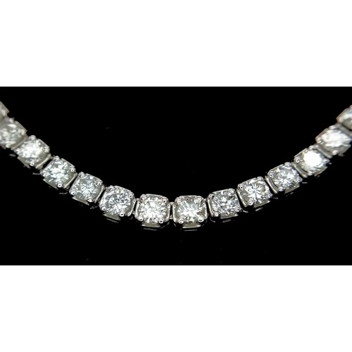 122 - An 18K White Gold with approx 6ct Diamond Tennis Necklace. 55 graduating round cut diamonds create a... 