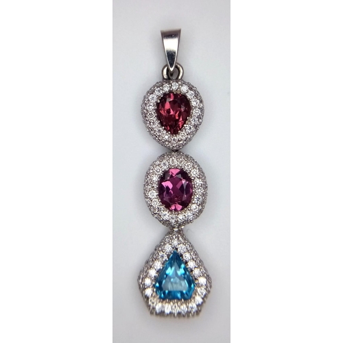 1533 - An 18K White Gold (tested) Ruby, Diamond and Topaz Drop Pendant. Three gemstones with diamond encrus... 