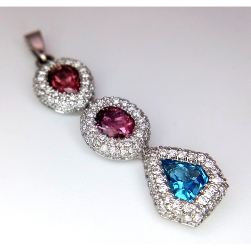 1533 - An 18K White Gold (tested) Ruby, Diamond and Topaz Drop Pendant. Three gemstones with diamond encrus... 