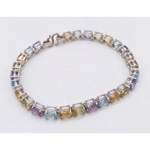 1234 - A 9K White Gold Multi-Gemstone Tennis Bracelet. Includes beautifully oval-cut faceted amethyst, topa... 