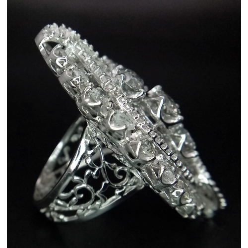 1261 - An 18K White Gold Diamond Dress Ring. This 'all seeing' diamond masterpiece begins with three centra... 