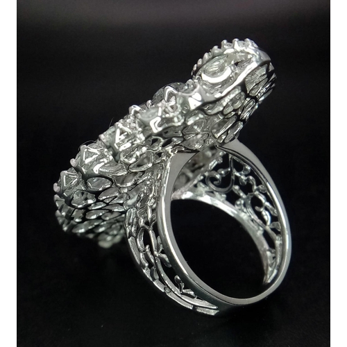 1261 - An 18K White Gold Diamond Dress Ring. This 'all seeing' diamond masterpiece begins with three centra... 