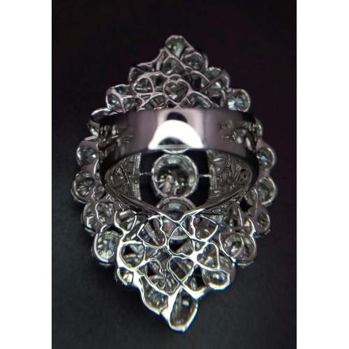 1261 - An 18K White Gold Diamond Dress Ring. This 'all seeing' diamond masterpiece begins with three centra... 