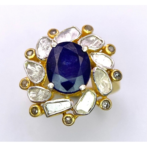 126 - An eye-catching silver and gold ring with an oval cut blue sapphire surrounded by a group of large n... 