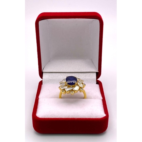 126 - An eye-catching silver and gold ring with an oval cut blue sapphire surrounded by a group of large n... 