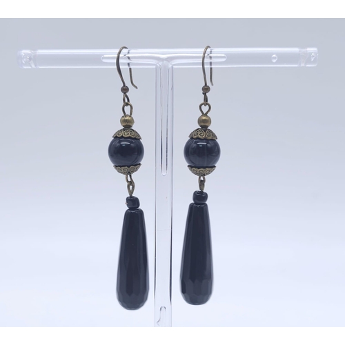 1642 - A Black Jet Jewellery Set. To include: faceted beaded necklace - 82cm. Drop earrings - 5cm and oval ... 