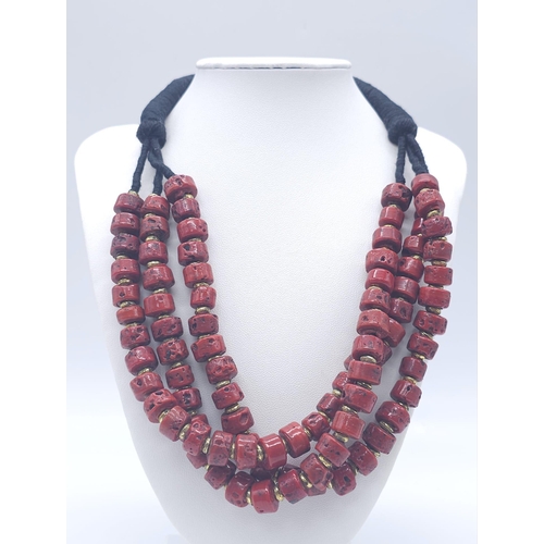 1691 - A Three Row Blood Red African Coral Necklace. Rondelle coral beads with gilded spacers. 44-48cm.