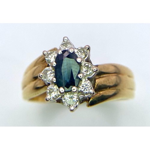 243 - A designer 18K Yellow Gold Ring with stunning central Sapphire surrounded by a halo of Diamonds.
Siz... 