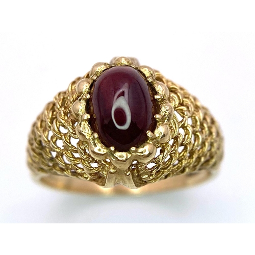 482 - A Vintage 9K Yellow Gold and Garnet Ring. Central oval garnet within a woven gold setting. Size O/P.... 