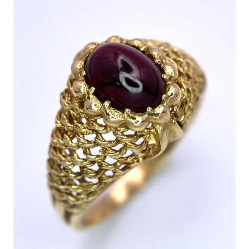 482 - A Vintage 9K Yellow Gold and Garnet Ring. Central oval garnet within a woven gold setting. Size O/P.... 