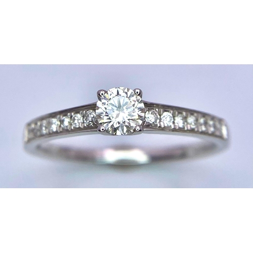 58 - An 18K White Gold Diamond Ring. Central brilliant round cut diamond with diamonds on shoulders. 0.34... 