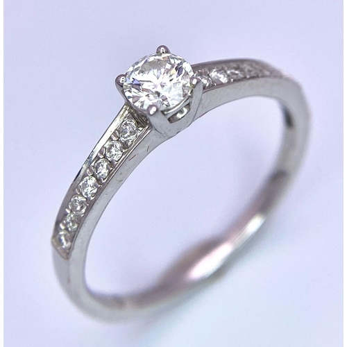 58 - An 18K White Gold Diamond Ring. Central brilliant round cut diamond with diamonds on shoulders. 0.34... 