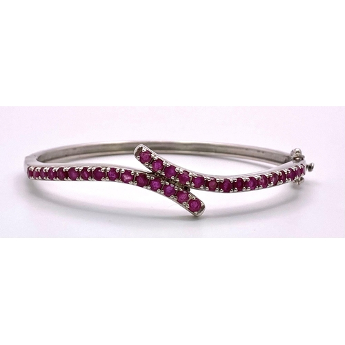 725 - A Ruby Gemstone Crossover Bangle/Bracelet. Set in 925 Silver. Clip open. 13.35g total weight. Ref: C... 