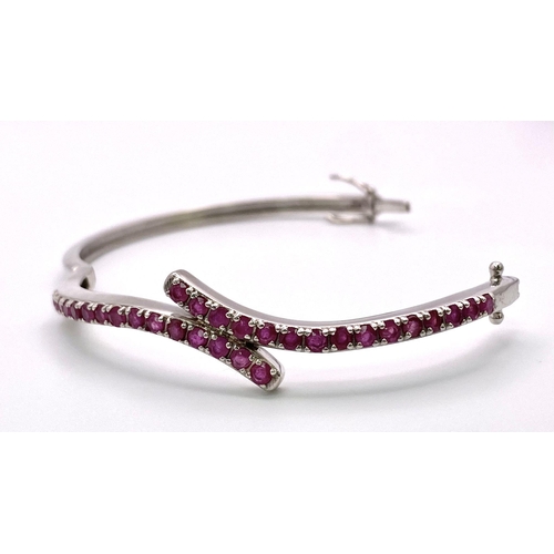 725 - A Ruby Gemstone Crossover Bangle/Bracelet. Set in 925 Silver. Clip open. 13.35g total weight. Ref: C... 