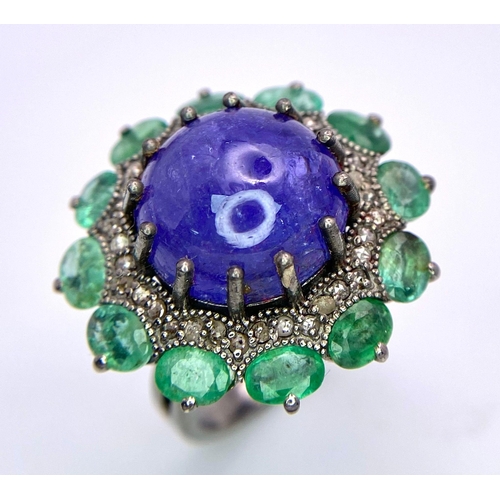 956 - A 11.80ct Tanzanite Cabochon Gemstone Ring with halos of 3.5ctw Emeralds and 0.70ctw Diamonds. Set i... 