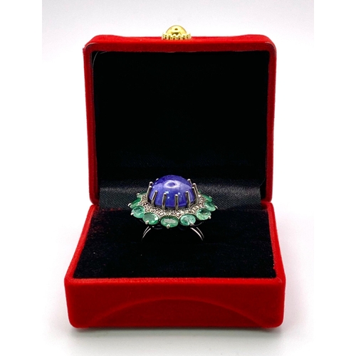 956 - A 11.80ct Tanzanite Cabochon Gemstone Ring with halos of 3.5ctw Emeralds and 0.70ctw Diamonds. Set i... 