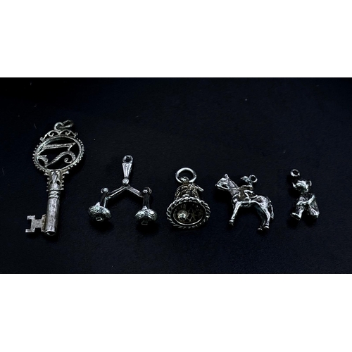 1703 - Collection of white metal Charms/Pendants.
Featuring a 21 Key, Scales, Horse & Rider, Bell and a che... 