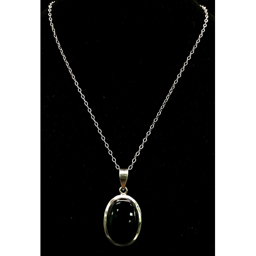 1146 - A Black Onyx Pendant Set in Silver on a Silver Chain. 4cm and 42cm.