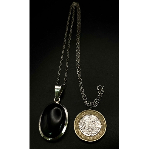 1146 - A Black Onyx Pendant Set in Silver on a Silver Chain. 4cm and 42cm.