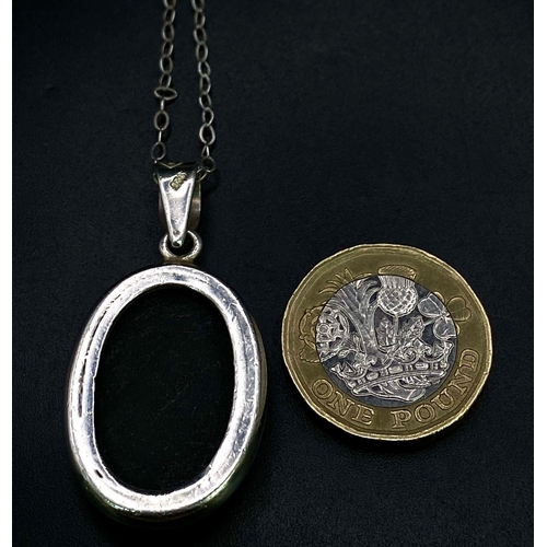 1146 - A Black Onyx Pendant Set in Silver on a Silver Chain. 4cm and 42cm.