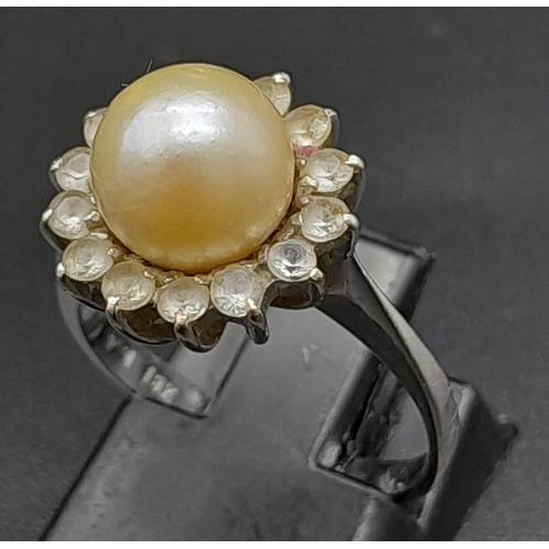 1761 - An 18K White Gold, Pearl and Diamond Ring. Central South Sea pearl with an old cut diamond halo. Siz... 