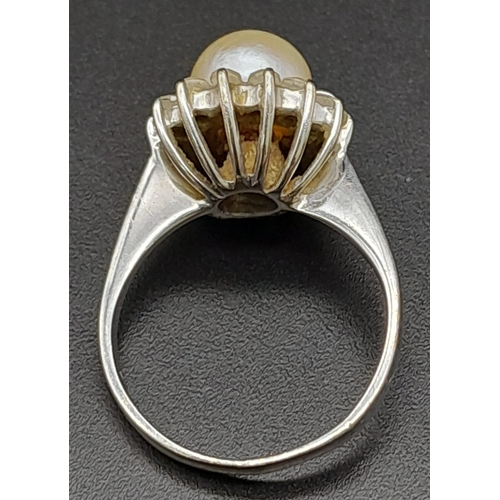 1761 - An 18K White Gold, Pearl and Diamond Ring. Central South Sea pearl with an old cut diamond halo. Siz... 