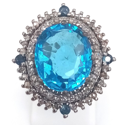 1384 - A 8.25ct Blue Topaz Ring with 0.95ct Diamond Accents and 0.20ct Blue Sapphire Accents on 925 Silver.... 