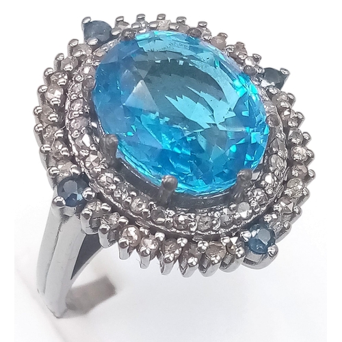 1384 - A 8.25ct Blue Topaz Ring with 0.95ct Diamond Accents and 0.20ct Blue Sapphire Accents on 925 Silver.... 